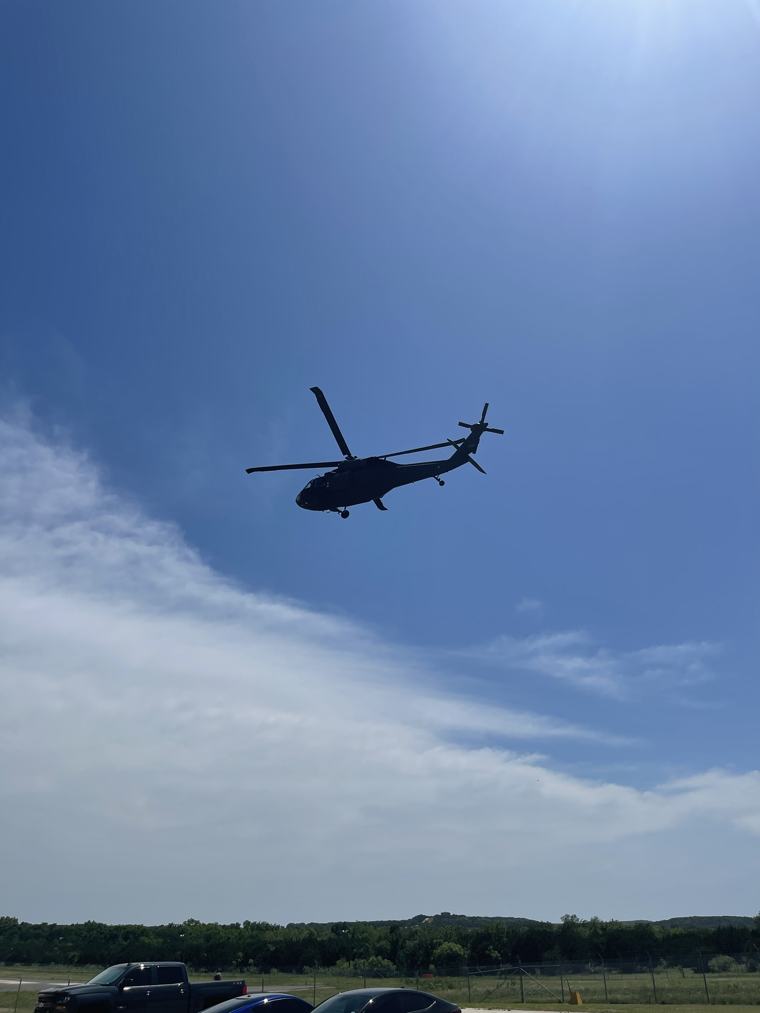 Blackhawk helicopter flying overhead against a blue sky